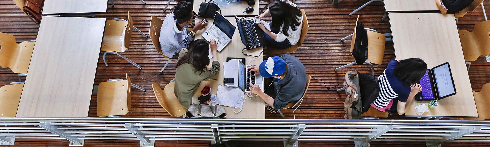 header étudiants travailant en open space sur ordinateurs