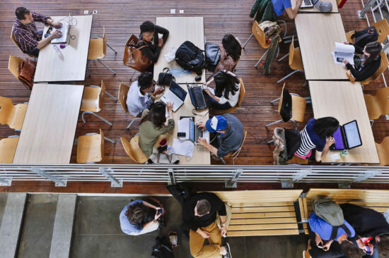 header étudiants travailant en open space sur ordinateurs