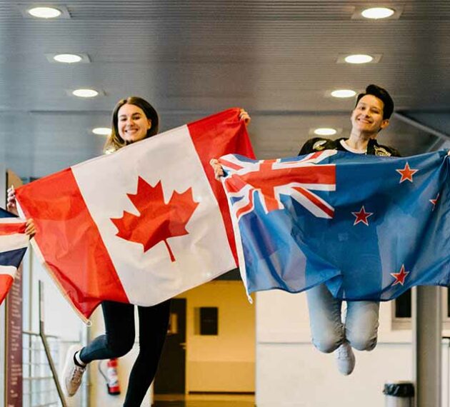 Etudiants sautant avec des drapeaux