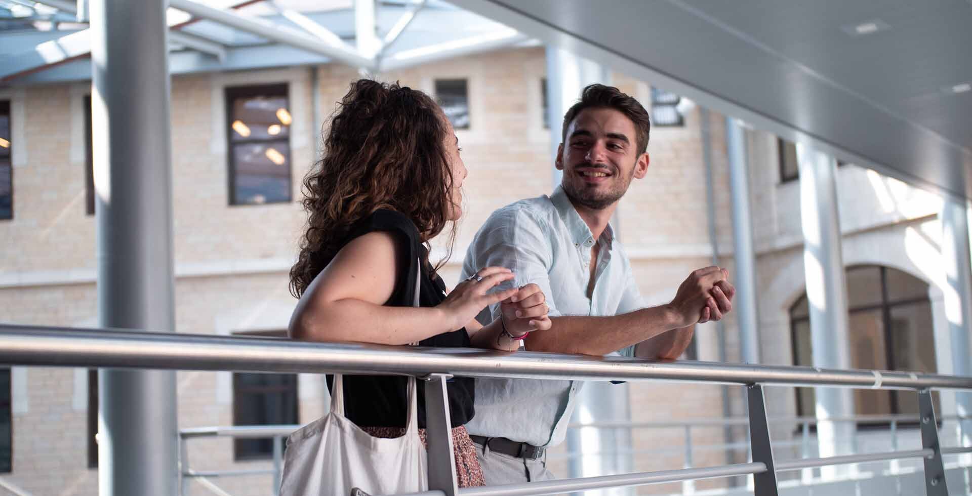 deux étudiants discutent sur la passerelle du campus Saint-Paul à Lyon