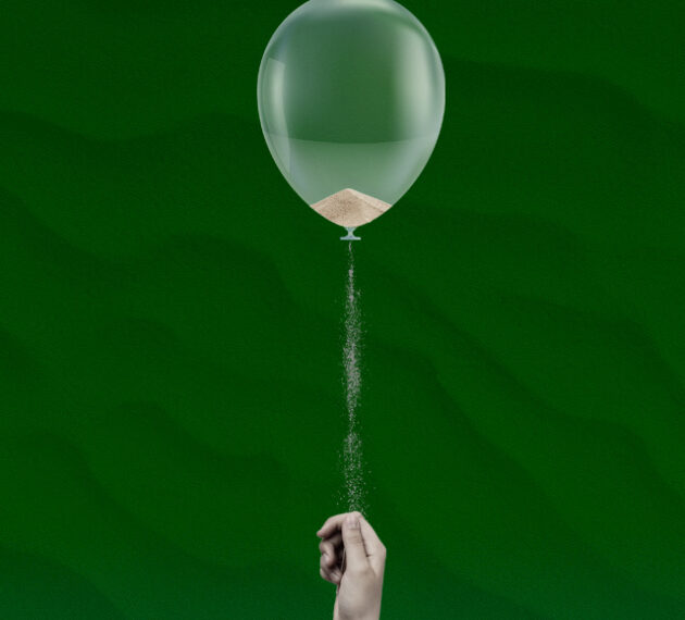 main qui tient un ballon duquel s'écoule du sable